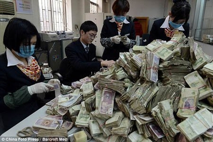 Nh&acirc;n vi&ecirc;n ng&acirc;n h&agrave;ng cho&aacute;ng với 15 bao tiền lẻ của kh&aacute;ch 2